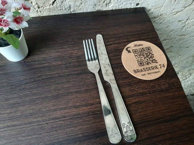 Drink's coaster on restaurant table beside cutlery