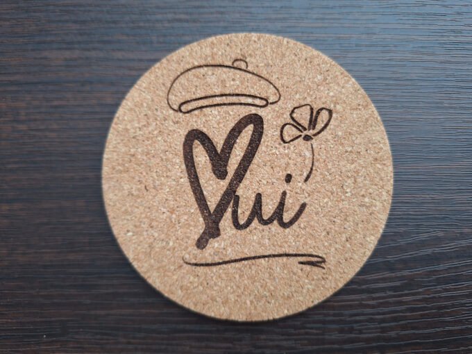 Cork material drink coaster with the word Oui engraved