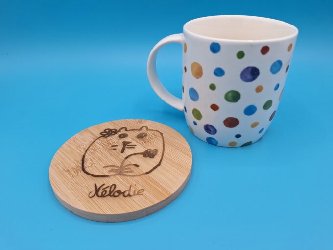 Image of bamboo drink coaster with child's artwork engraved by laser